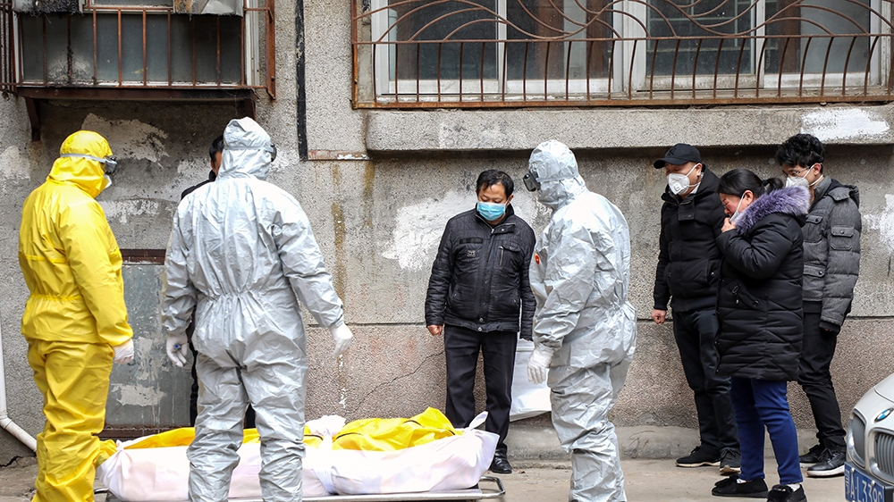 Funeral house workers take the body of a resident, who reportedly died because of the novel coronavirus (2019-nCoV) at home, out of a residential building in Wuhan, in central China''s Hubei province,