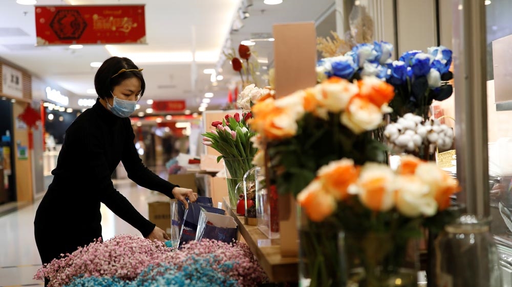 A florist who prefers to be called Cai Xiaoman wearing a face mask at a flowers shop in Beijing.