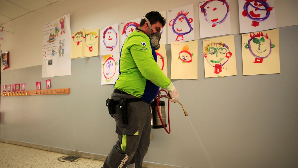 An employee from a disinfection company sanitises a closed school in Sidon, Lebanon