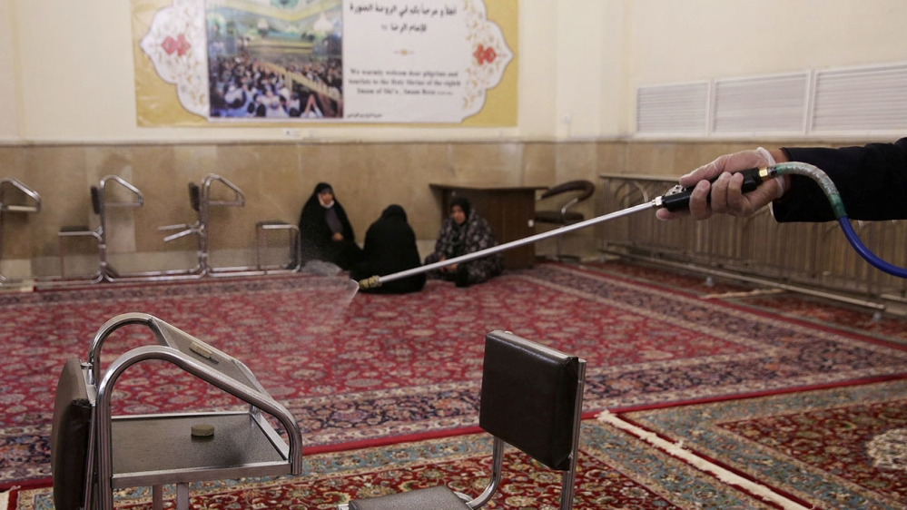 A member of a medical team sprays disinfectant to sanitise the inside of Imam Reza’s holy shrine, following the coronavirus outbreak, in Mashhad, Iran on February 27, 2020 [West Asia News Agency via Reuters]