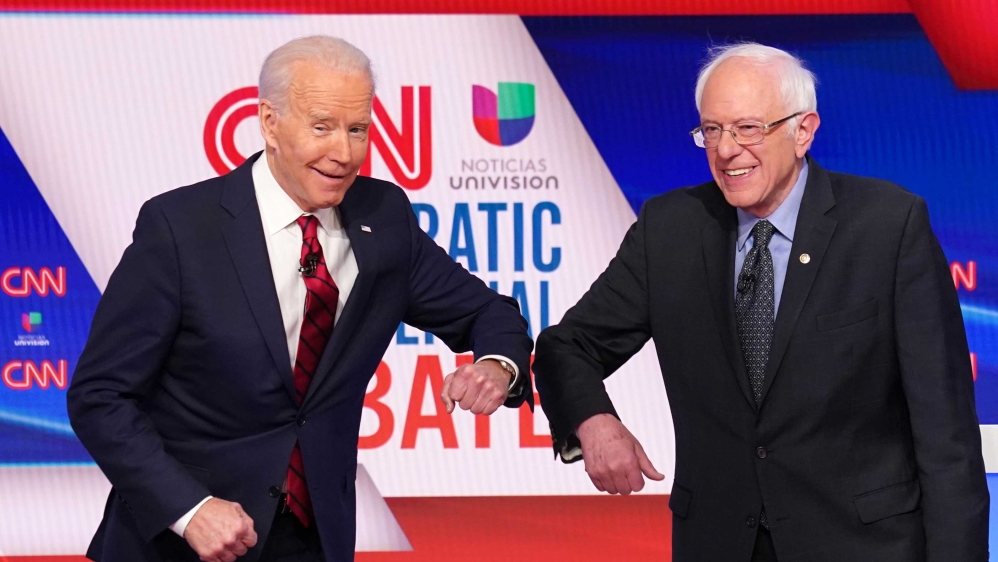 Democratic US presidential candidates former Vice President Joe Biden and Senator Bernie Sanders do an elbow bump in place of a handshake as they greet other before the start of the 11th Democratic candidates’ debate held in CNN’s studio without an audience because of the global coronavirus pandemic, in Washington, US