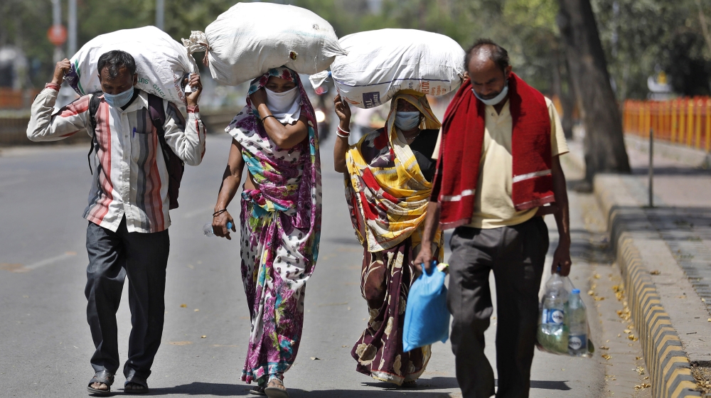 A group of daily wage laborers walk to return to their villages as the city comes under lockdown in Prayagraj, India, Monday, March 30, 2020. The nationwide lockdown announced last week by Prime Minis
