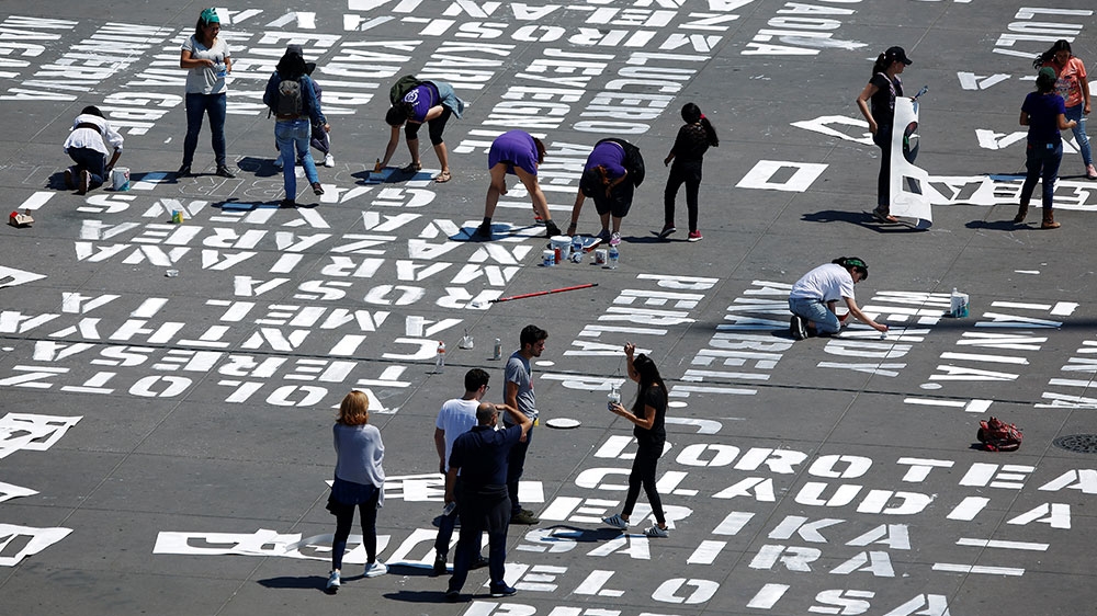 Women paint the names of femicide victims as part of a protest marking International Women’s Day, at Zocalo square in Mexico City, Mexico