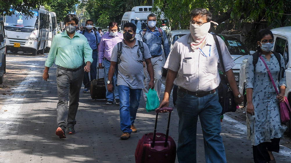Governmental doctors walk towards a bus to go to several districts as reinforcement in the city during a government-imposed nationwide lockdown