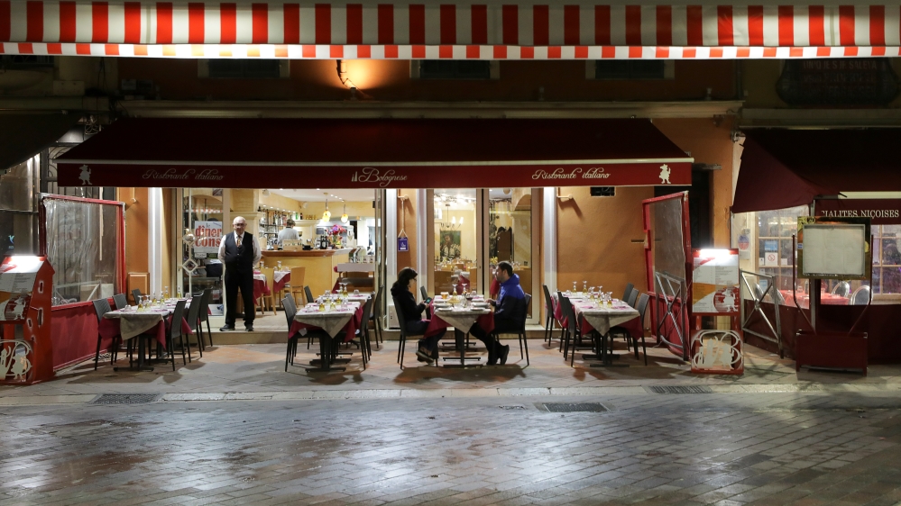 A couple sits in a restaurant, as France''s Prime Minister announced to close most all non-indispensable locations, notably cafes, restaurants, cinemas, nightclubs and shops from midnight in Nice