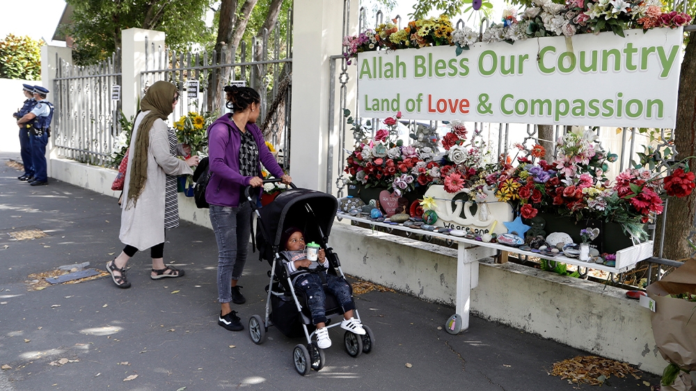A woman prepares to lay flowers outside the Al Noor mosque in Christchurch, New Zealand, Saturday, March 14, 2020. A national memorial in New Zealand to commemorate the 51 people who were killed when a gunman attacked two mosques one year ago has been cancelled due to fears over the new coronavirus