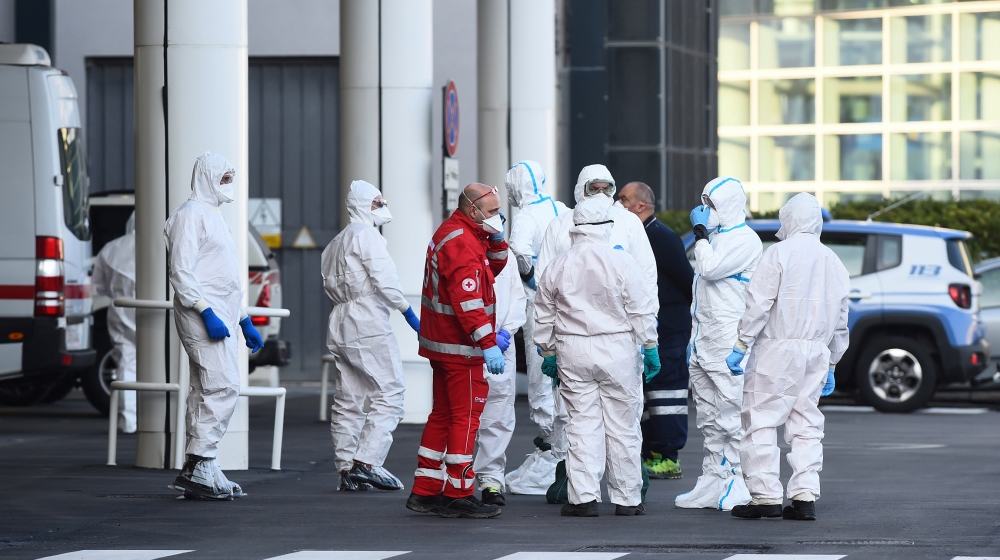 Health workers and members of Italian Red Cross are seen near the Costa Luminosa cruise ship that was hit by the coronavirus disease (COVID-19), at the port of Savona, near Genoa, in Italy, March 21,