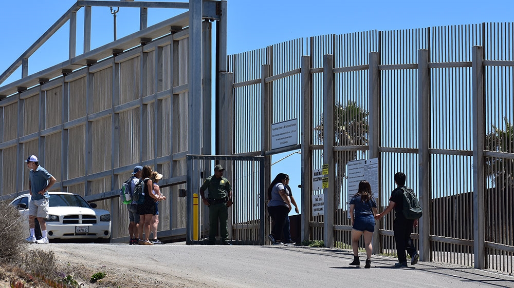 A Border Patrol agent guards an entrance to a ‘friendship park’ within Tijuana Riverine Estuary and the Border Field State Park in San Diego, California [Molly McCluskey/Al Jazeera] [