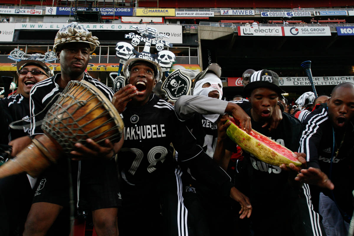 Soccer fans of Orlando Pirates eat from a water melon as a symbol of how they will ‘ eat up’ Kaizer cheifs by scoring many goals against them. .Photo Antony kAMINJU
