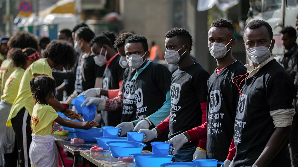 Volunteers stand ready to provide soap and water for participants to wash their hands against the new coronavirus at a women's 5km fun run in the capital Addis Ababa, Ethiopia Sunday, March 15, 2020.