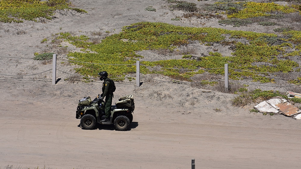 A Border Patrol agent patrols on an ATV in Tijuana Riverine Estuary and the Border Field State Park in San Diego, California