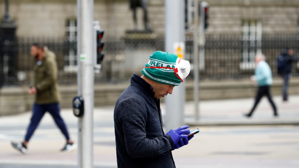 A man looks at his phone in Dublin as the spread of the coronavirus continues in Dublin, Ireland