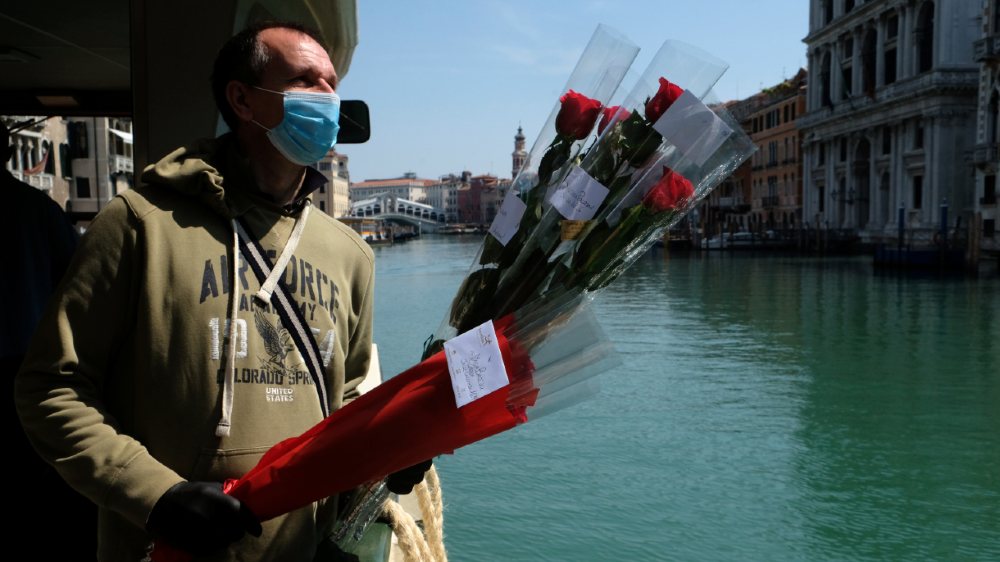 A man delivers roses, symbol of the patron of Venice Saint Mark, on his feast day during the coronavirus lockdown across the country in Venice, Italy