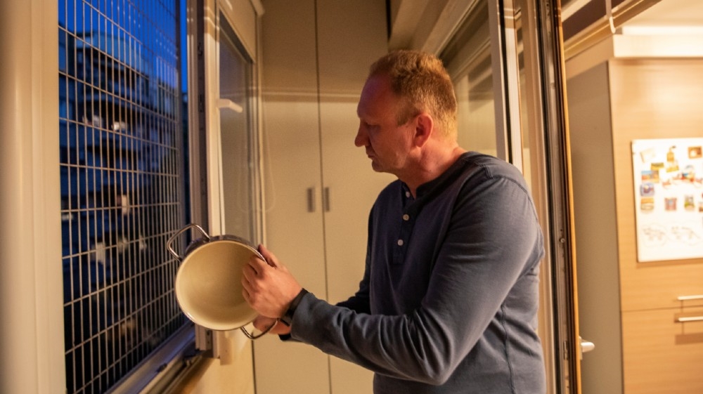 Dragan Djilas, the head of the opposition Alliance for Serbia, bangs a pot from his terrace to protest government policies during the coronavirus crisis in Belgrade, Serbia