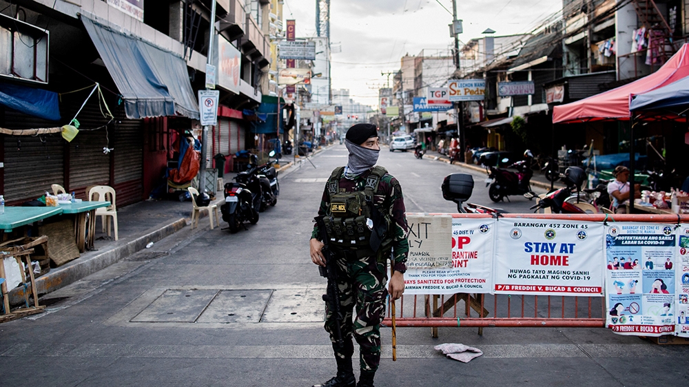 A soldier guards an empty street following the lockdown imposed to contain the coronavirus disease in Manila, Philippines