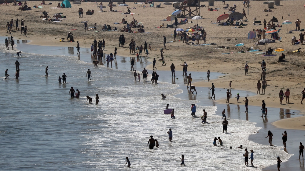 People are seen gathering on the Corona del Mar State Beach on April 25, 2020 in Newport Beach, California