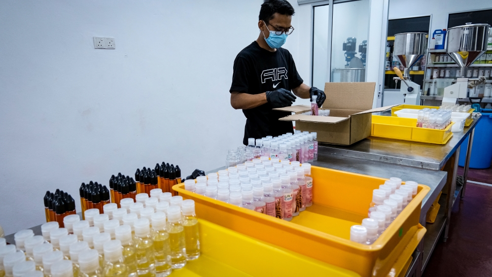 A worker boxes the bottle of hand sanitisers in a small laboratory in Selangor, Malaysia