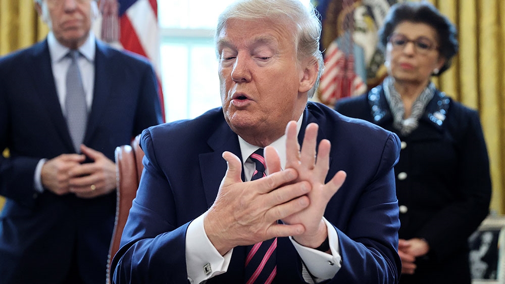 US President Donald Trump rubs his hands while defending his comments on using household disinfectants as a measure against the coronavirus