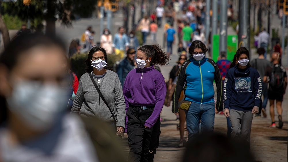 Families walk along a boulevard in Barcelona as the lockdown to combat the spread of coronavirus continues
