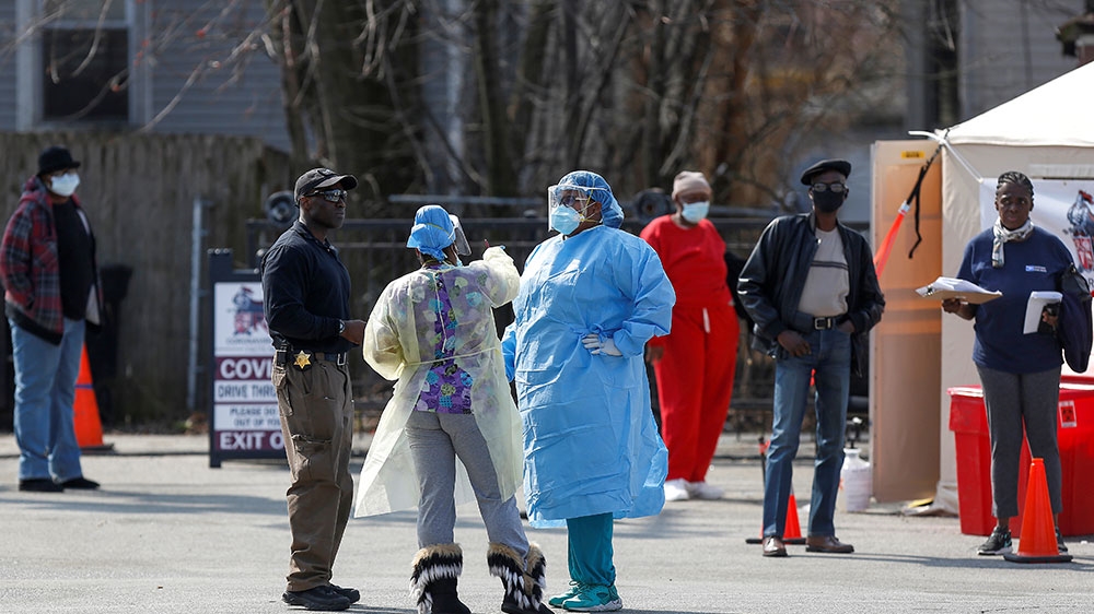 Medical workers talk as people wait in line to receive testing during the global outbreak of coronavirus disease (COVID-19) outside Roseland Community Hospital in Chicago, Illinois [Joshua Lott/Reuters] [Daylife]