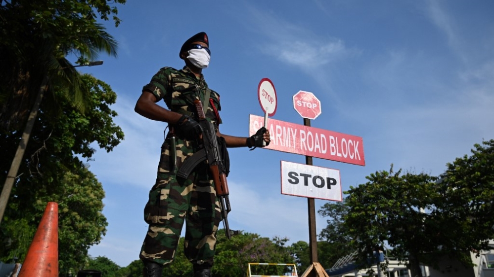 A Sri Lankan army personnel wearing a facemask holds a stop sign at a checkpoint during a government-imposed nationwide lockdown as a preventive measure against the COVID-19 outbreak in Colombo on April 29, 2020