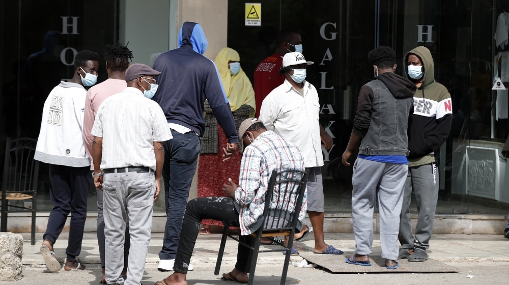 Migrants wearing face masks to protect from coronavirus gather at the entrance of a hotel in Kranidi town about 170 kilometers (106 miles) southwest of Athens, Tuesday, April 21, 2020. The heads of Gr