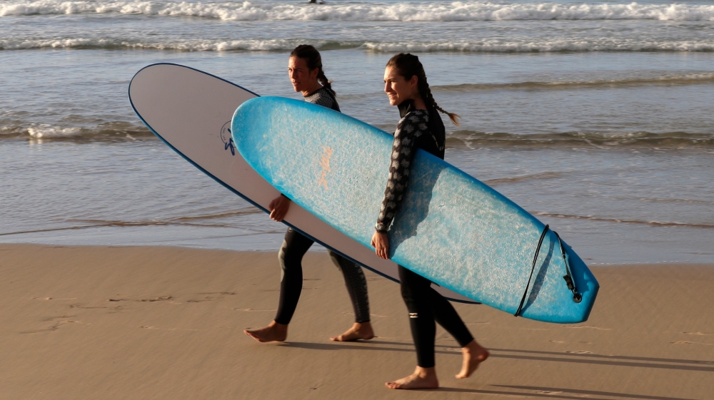 Surfers prepare to enter the water at Bondi Beach in Sydney as coronavirus pandemic restrictions are eased