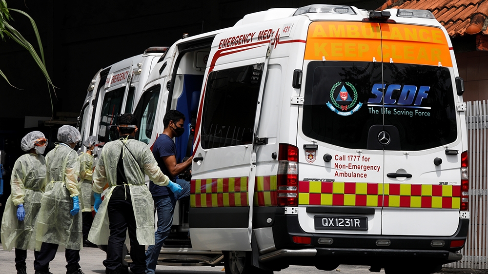Medical personnel assist a migrant worker as he enters an ambulance at a factory-converted dormitory, amidst the coronavirus disease (COVID-19) outbreak in Singapore