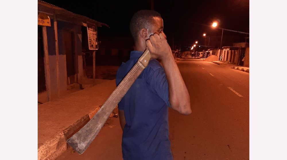 Teacher Awosusi Ahmed keeping vigil in front of his Lagos home to prevent attacks on his family [Al Jazeera]