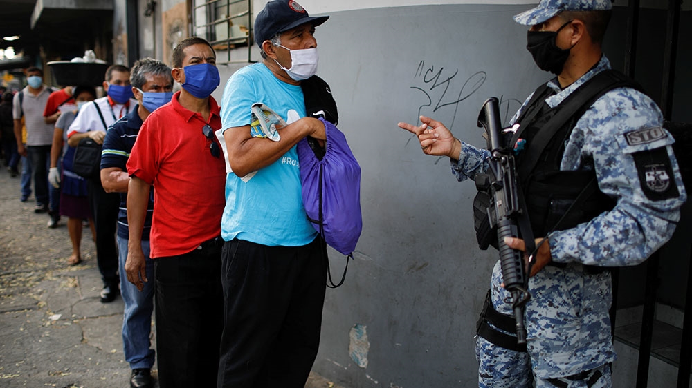 A policeman asks for documents at a checkpoint during a police and army joint operation in San Salvador, El Salvador