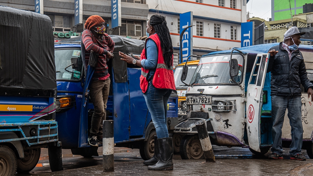 A member of Kenya Red Cross informs tuk-tuk drivers about the coronavirus in the central business district of Nairobi