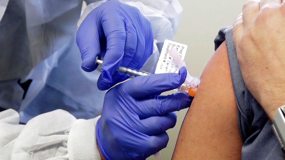 Neal Browning receives a shot in the first-stage study of a potential vaccine for COVID-19, the disease caused by the new coronavirus