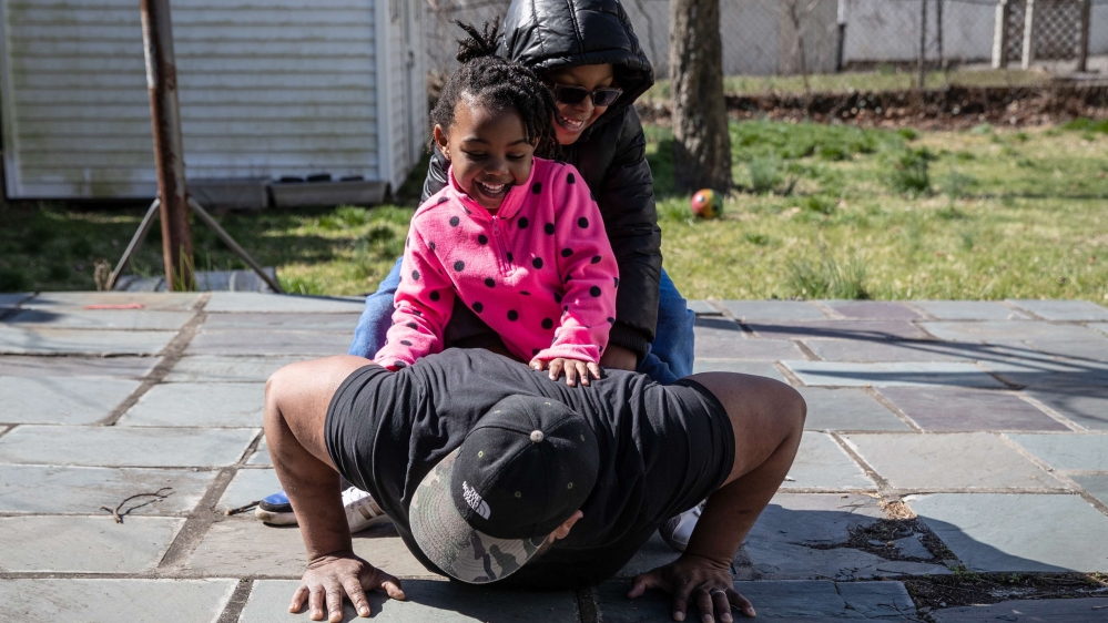 Chef Mo Major exercises in the back yard with his children Marley, 4, and Max, 5, in Mount Vernon, New York