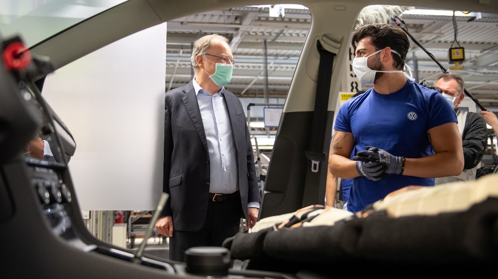 Lower Saxony’s Prime Minister Stephan Weil and a worker wear protective masks at the Volkswagen assembly line after the company restarts Europe’s largest car factory after coronavirus shutdown in Wolfsburg, Germany