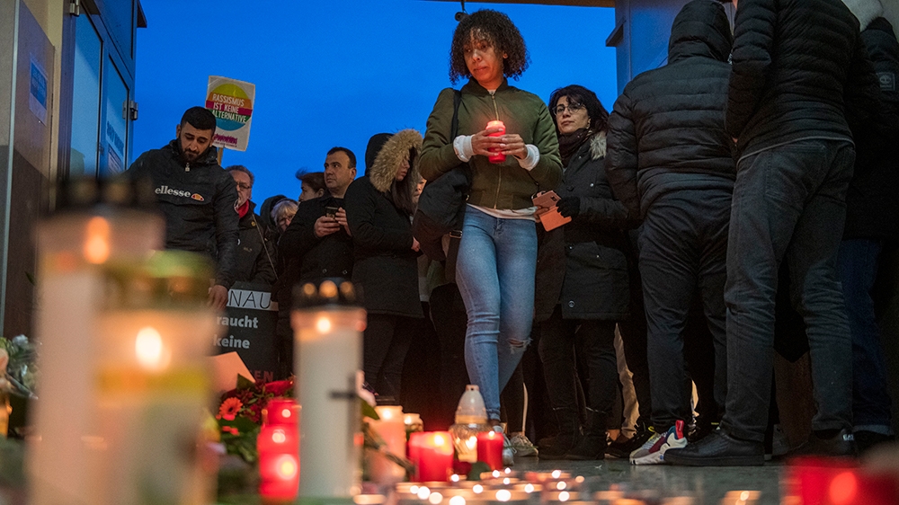 People gather in front of the Arena Bar and Cafe to commemorate the victims of the shooting