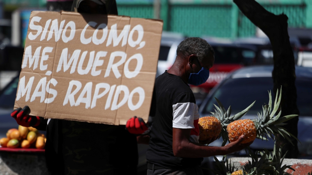 A man holding up a sign reading ‘If I don’t eat, I die faster’ in front of the central market as he protests against the measures taken by the government during the outbreak of the coronavirus disease, in Santo Domingo, the Dominican Republic