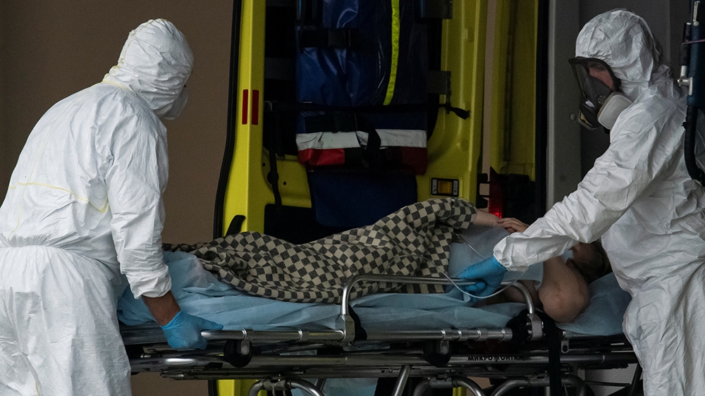 Medics transport a person outside a COVID-19 hospital on the outskirts of Moscow, Russia