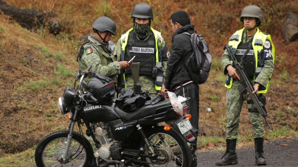 Members of the National Guard checks documents at a military check point outside the town of Uruapan