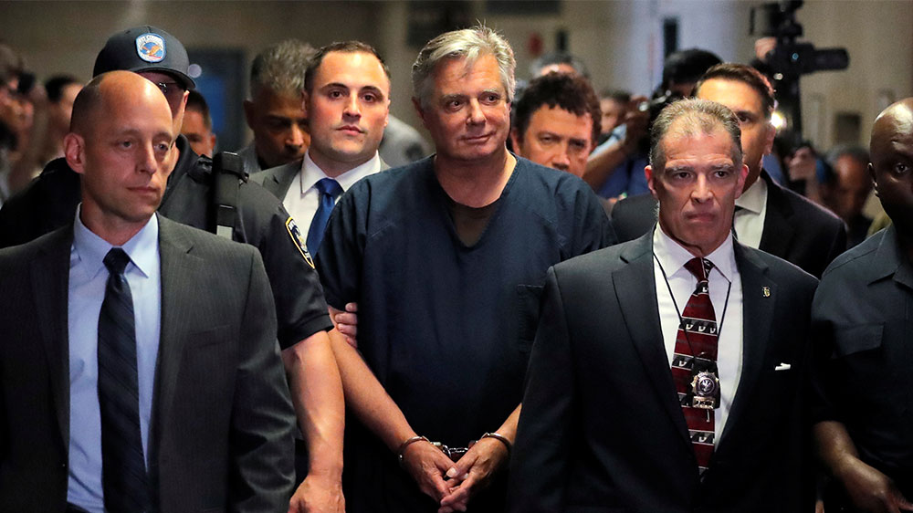 Former Trump campaign chairman Paul Manafort, centre, is escorted into court for his arraignment in New York Supreme Court in New York City