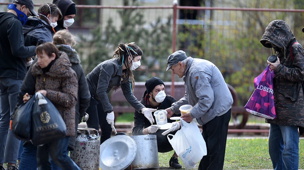 Volunteers wearing face masks distribute meals to homeless people in central Minsk, on May 2, 2020, during the COVID-19 outbreak, caused by the novel coronavirus