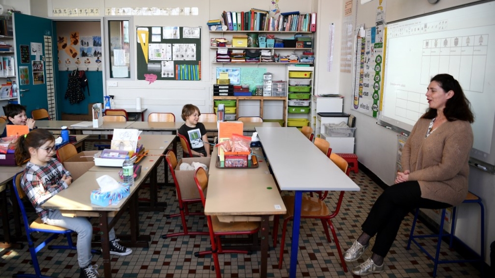 Pupils observing social distance rules listen to their teacher at the Saint Germain de Charonne school in Paris on May 14, 2020, as primary schools in France reopen this week