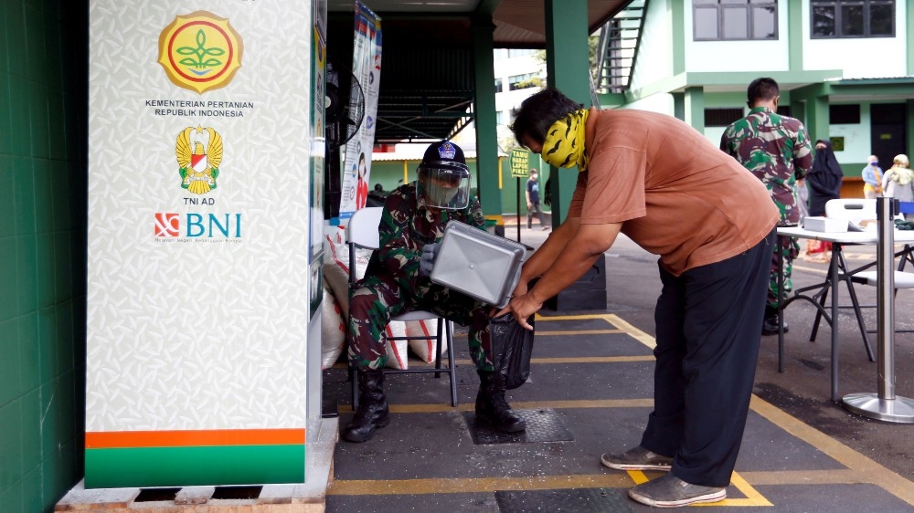 A man collects his rice ration from an automated dispenser in Jakarta last week