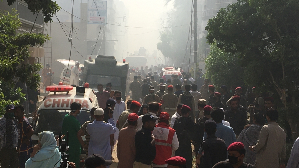 Ambulances and fire brigade vehicles gather at the site of a passenger plane crash in a residential area near an airport in Karachi, Pakistan May 22, 2020. REUTERS/Akhtar Soomro
