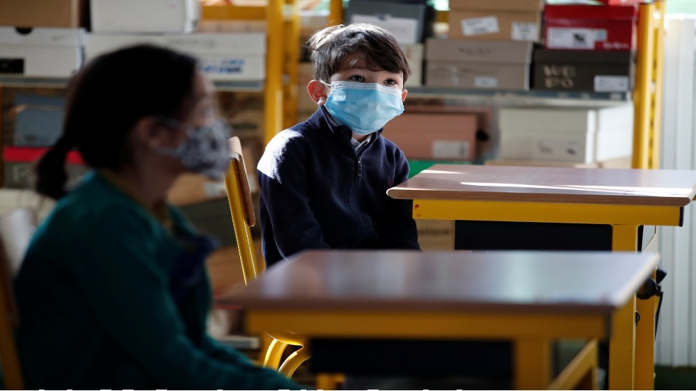 Pupils wearing protective face masks are seen in a classroom at a primary school during its reopening in Paris