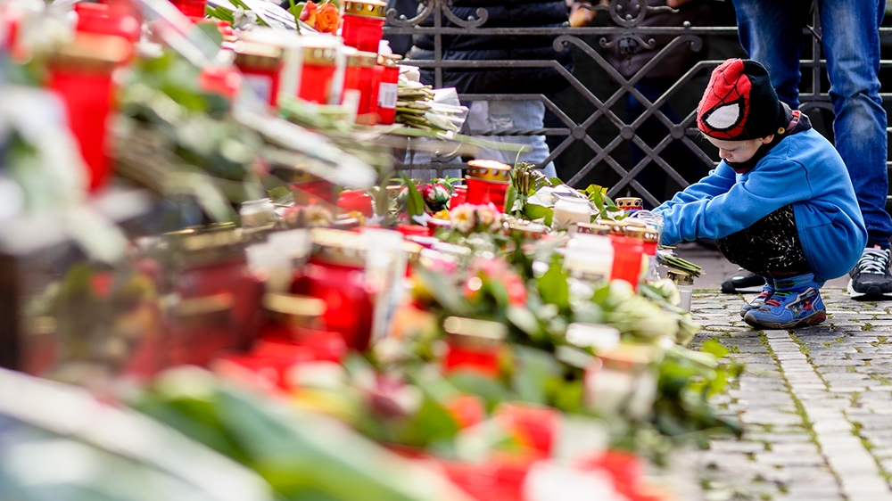 Mourners lay down flowers and light candles on the foundation of the Brothers-Grimm-Monument to commemorate the victims of the right-wing attack
