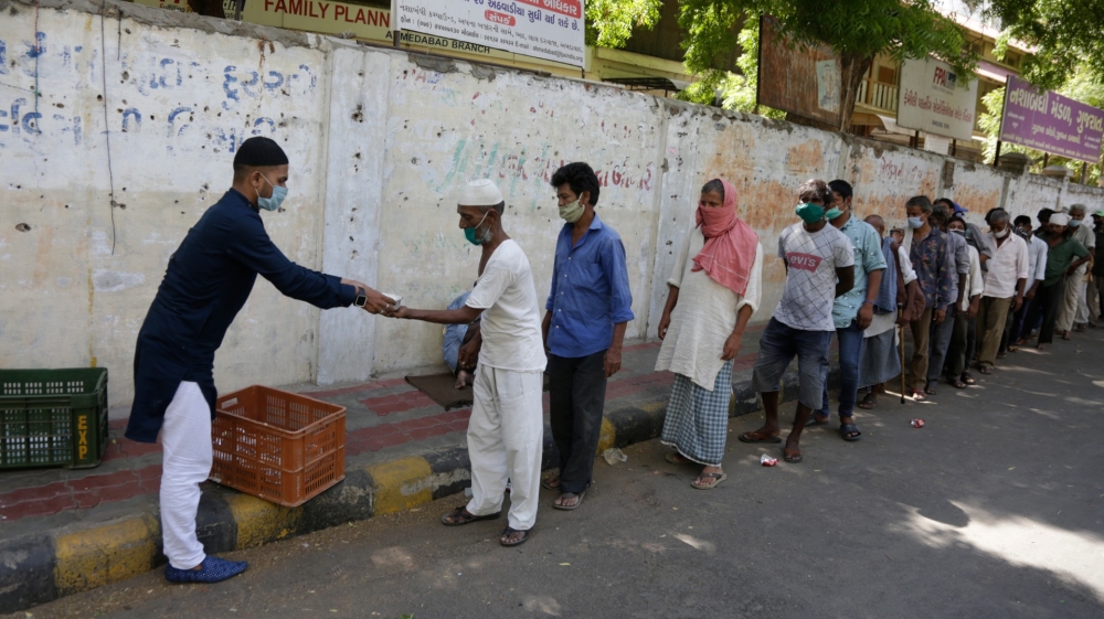 An Indian Muslim distributes kheer, a sweet dish, to homeless people on Eid al-Fitr in Ahmedabad, India