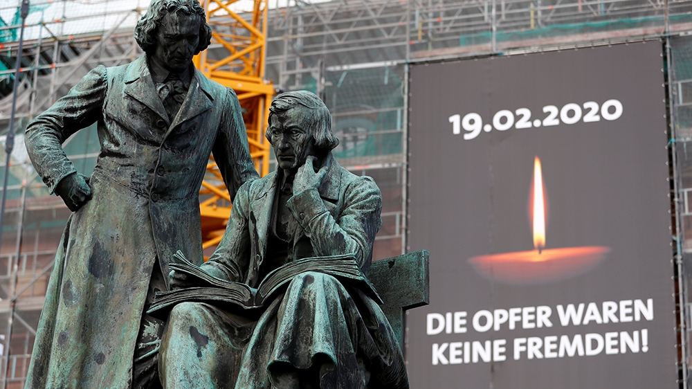 A placard reading The victims were not foreigners is pictured near the Brothers Grimm monument ahead of a memorial service for the victims of the shootings in Hanau, Germany, March 4, 2020