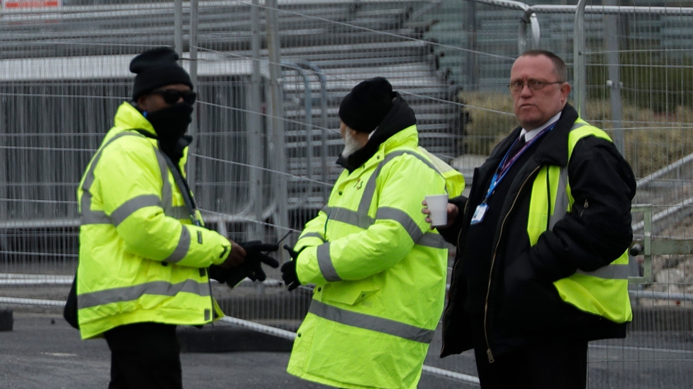 A group of security guards is joined by a member of the British army outside the ExCel centre, which was being turned into a 4,000-bed temporary hospital called NHS Nightingale to deal with coronavirus patients in London, Monday, March 30, 2020