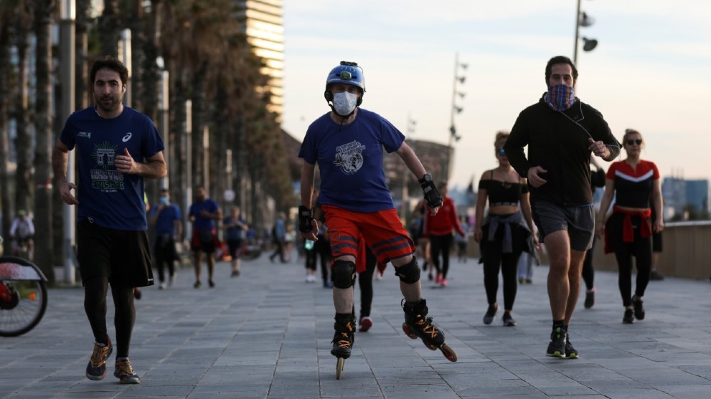 People exercise at the Barceloneta beach during the hours in which individual exercise is allowed outdoors, for the first time since the lockdown was announced, amid the c