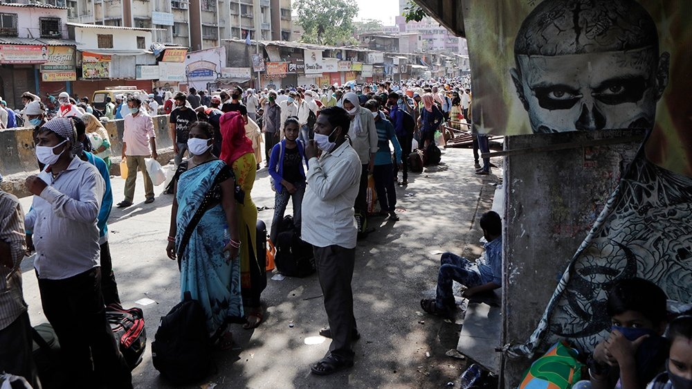 Migrant workers gather for transport to a train station for their onward journey to Uttar Pradesh and Bihar at Dharavi slum in Mumbai